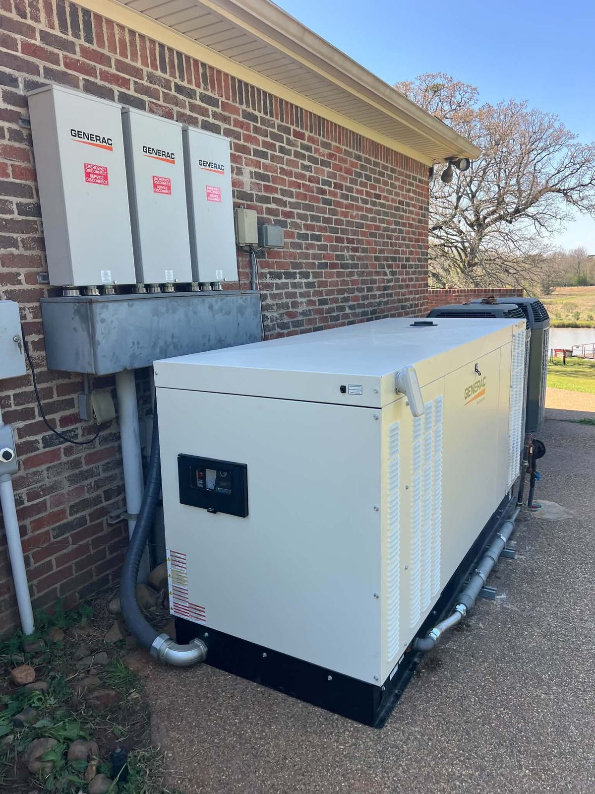 Generac standby generator installed beside a brick home
