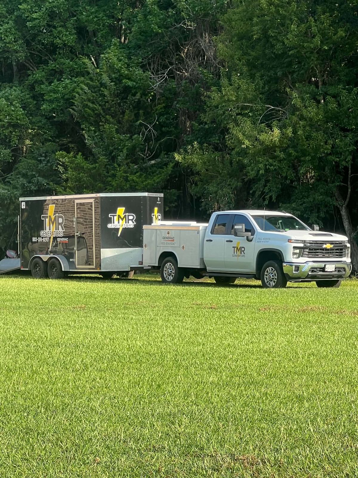 TMR Generators truck and trailer parked on grass