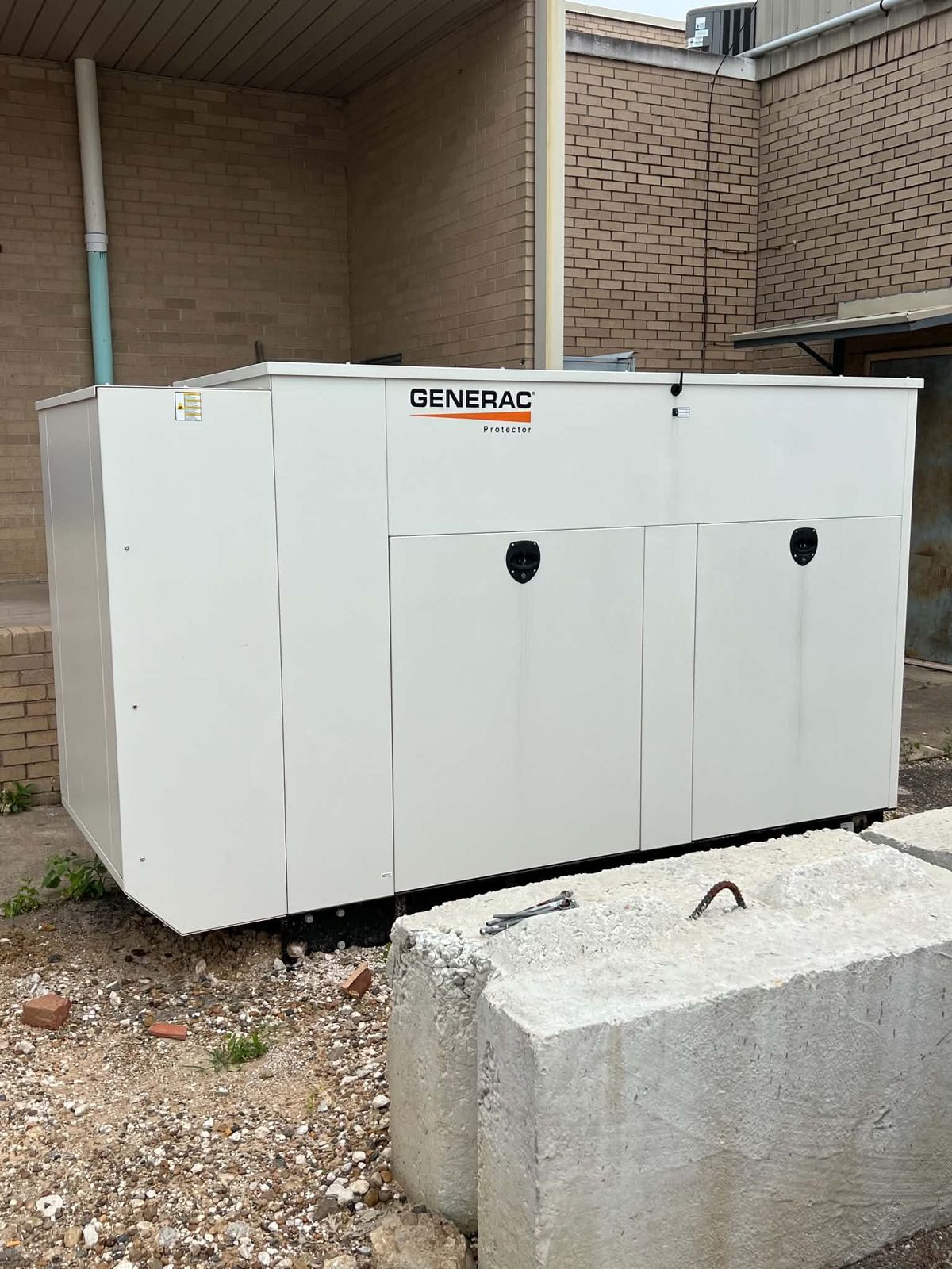 Large white Generac standby generator installed beside a commercial building